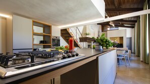 Una cocina moderna con una isla central, horno empotrado y electrodomésticos de acero inoxidable.