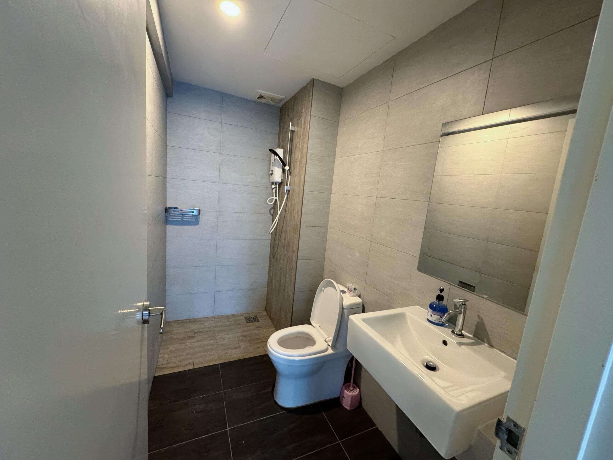 A modern bathroom with a toilet, sink, and shower area.