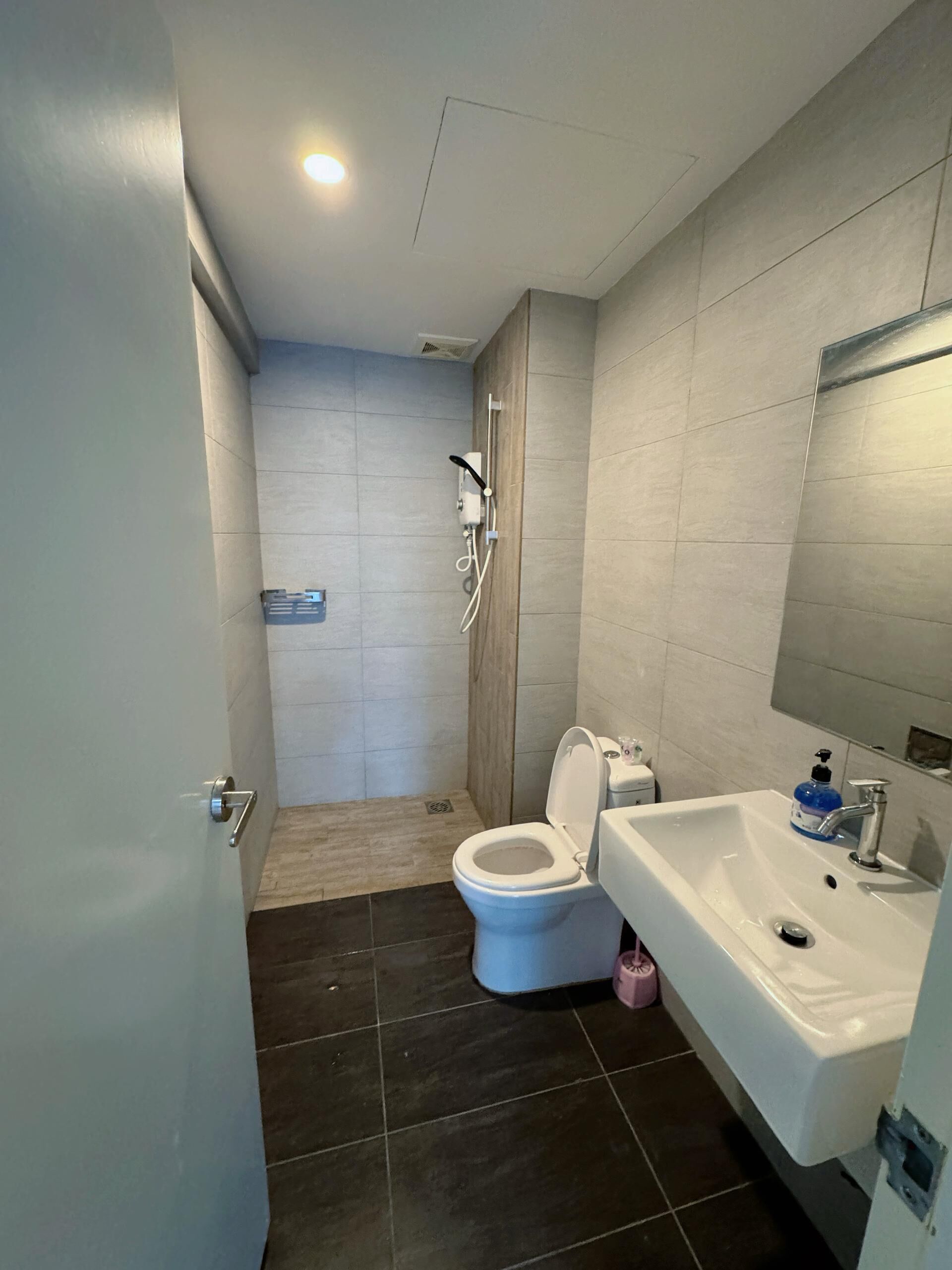 Een moderne badkamer met toilet, douche en wastafel.