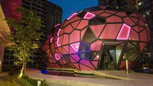 A modern spherical building with geometric patterns and pink lighting, surrounded by urban infrastructure. - Comfy Arte Plus Ampang City 7PAX-3BR-2CP (Kuala Lumpur)