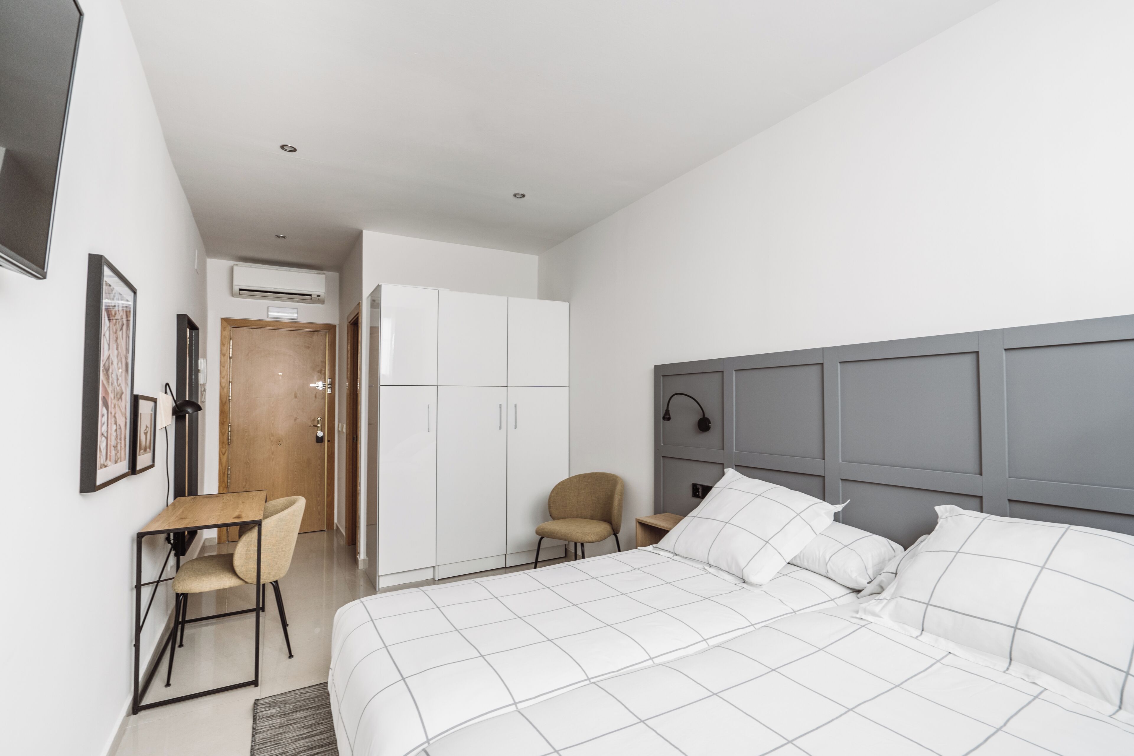 Une chambre moderne avec un grand lit, un bureau et une chaise.
