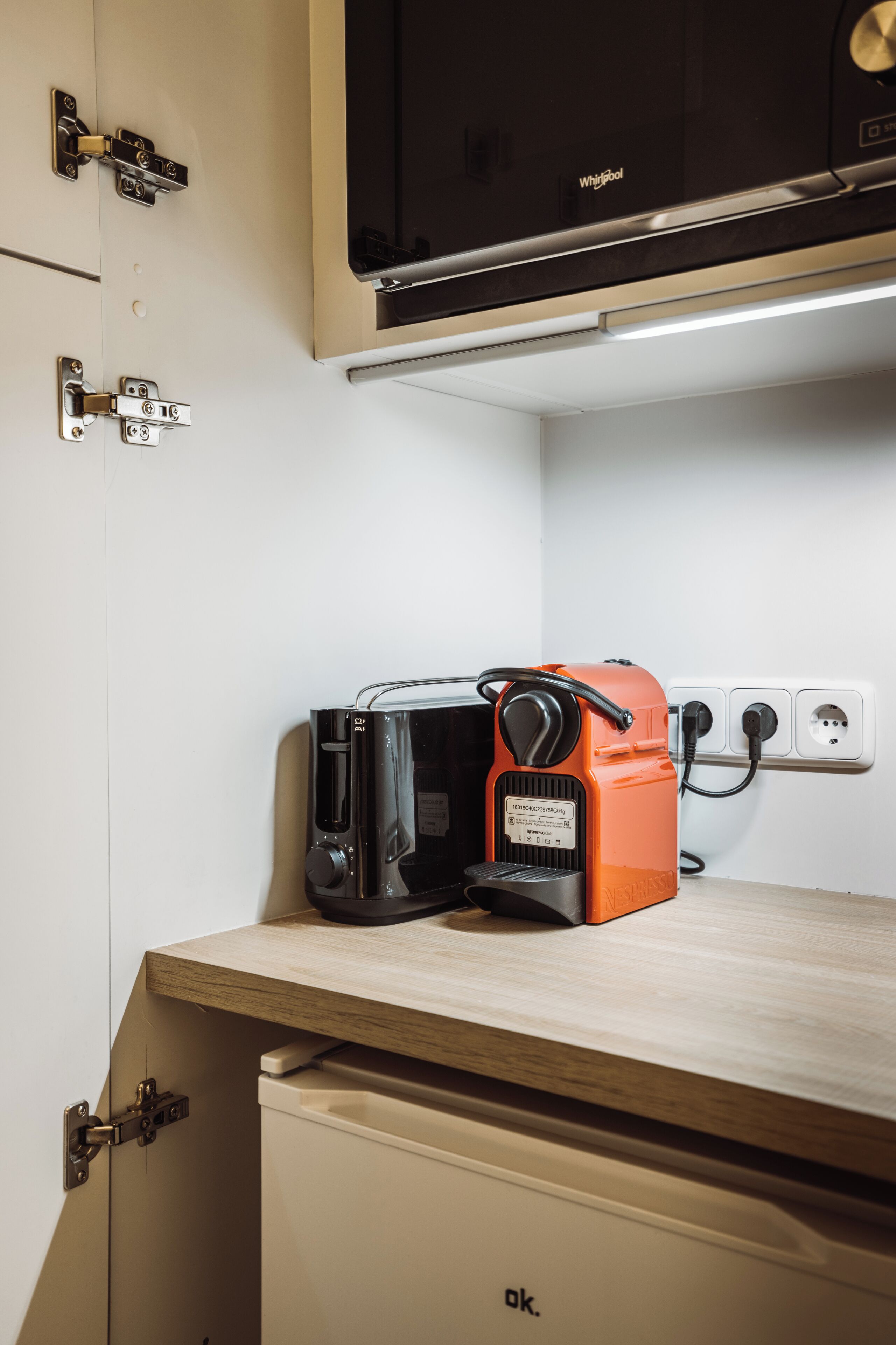 Une petite cuisine équipée d’un four à micro-ondes, d’un grille-pain et d’un petit réfrigérateur.