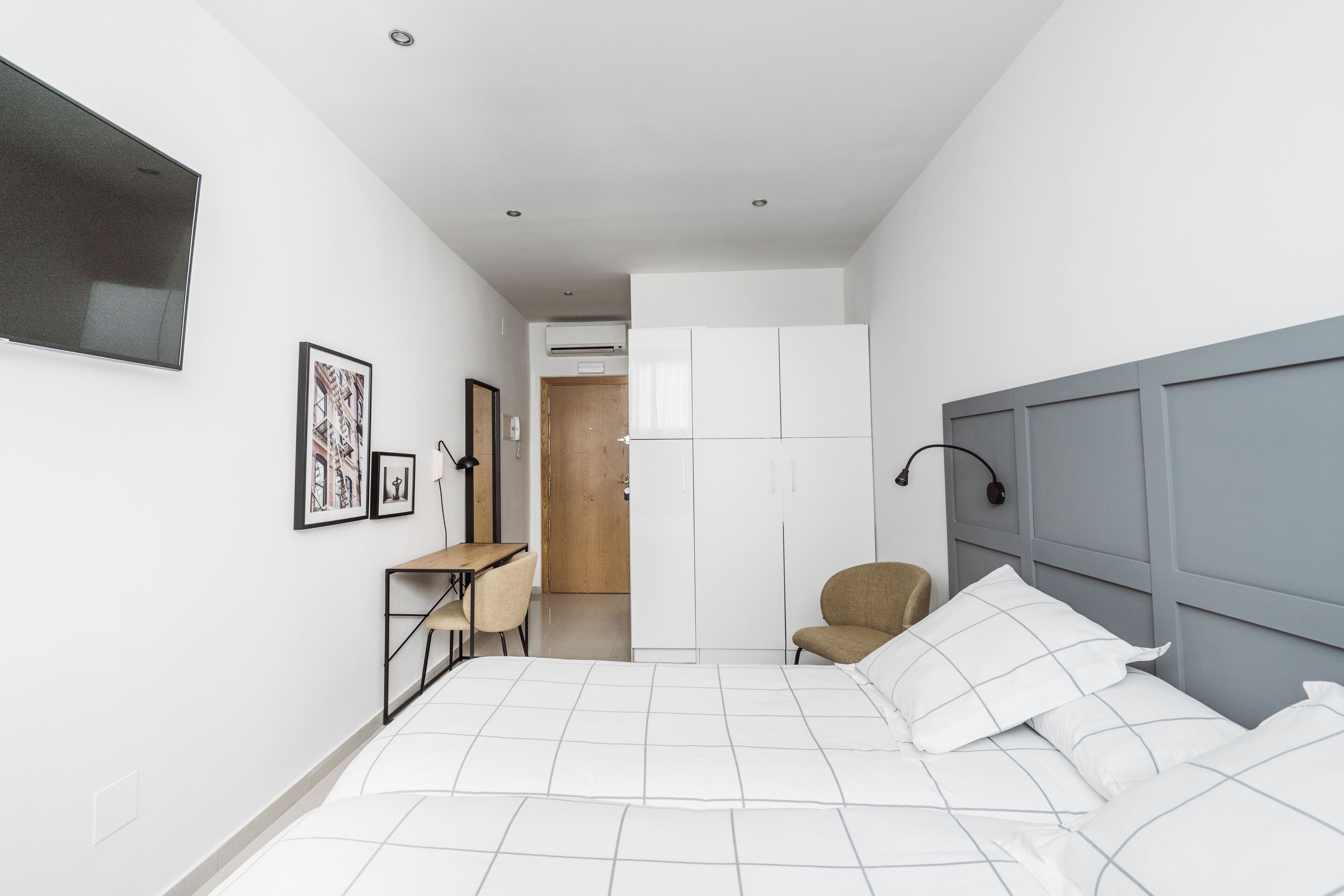A modern bedroom with a bed, a desk, and a chair.