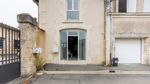 Un edificio con un acceso numerado, una puerta de garaje y una valla de metal negro.