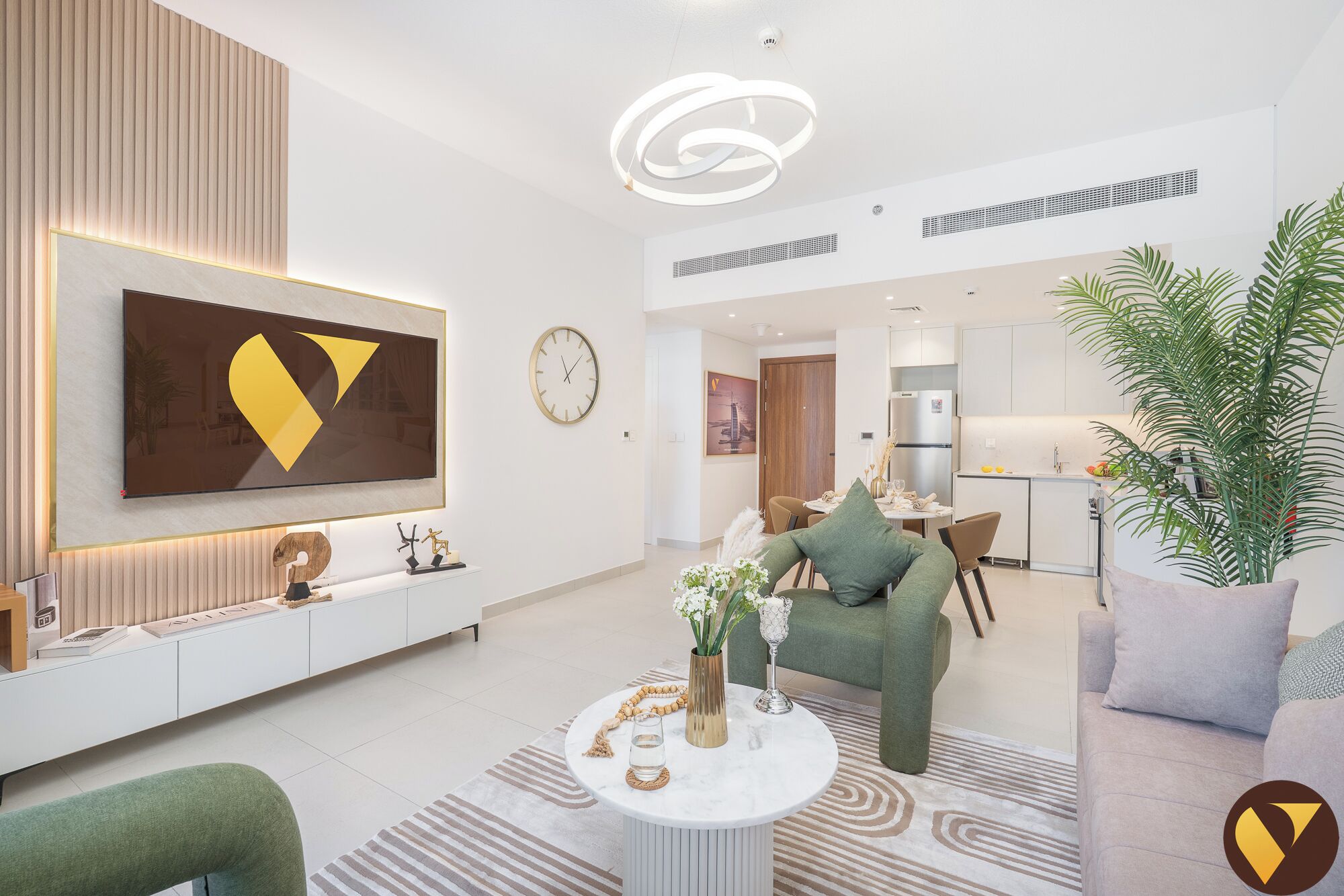 Ein modernes Wohnzimmer mit großem Fernseher, einem Essbereich und einer Küche.