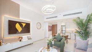 Ein modernes Wohnzimmer mit großem Fernseher, einem Essbereich und einer Küche.