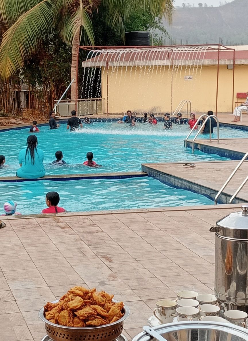 Una piscina con gente disfrutando, una zona cubierta con techo y una mesa con un bol de aperitivos fritos y vasos.