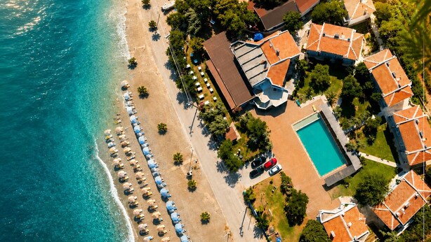 An aerial view of a coastal resort with a beach, a swimming pool, and multiple villas. - Blue Park Assos (Ayvacik)