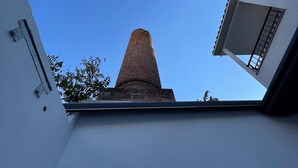 A tall brick tower with a clear blue sky in the background. - Arada Ayvalık (Ayvalik)