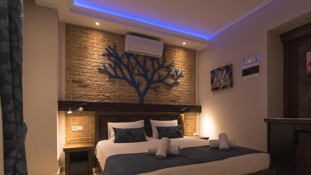 Ein Schlafzimmer mit Backsteinwand, einer baumförmigen Dekoration, einem Bett mit Kissen und einem Nachttisch.