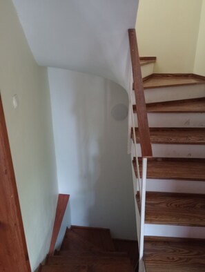Staircase leads upwards with a light switch on the wall.