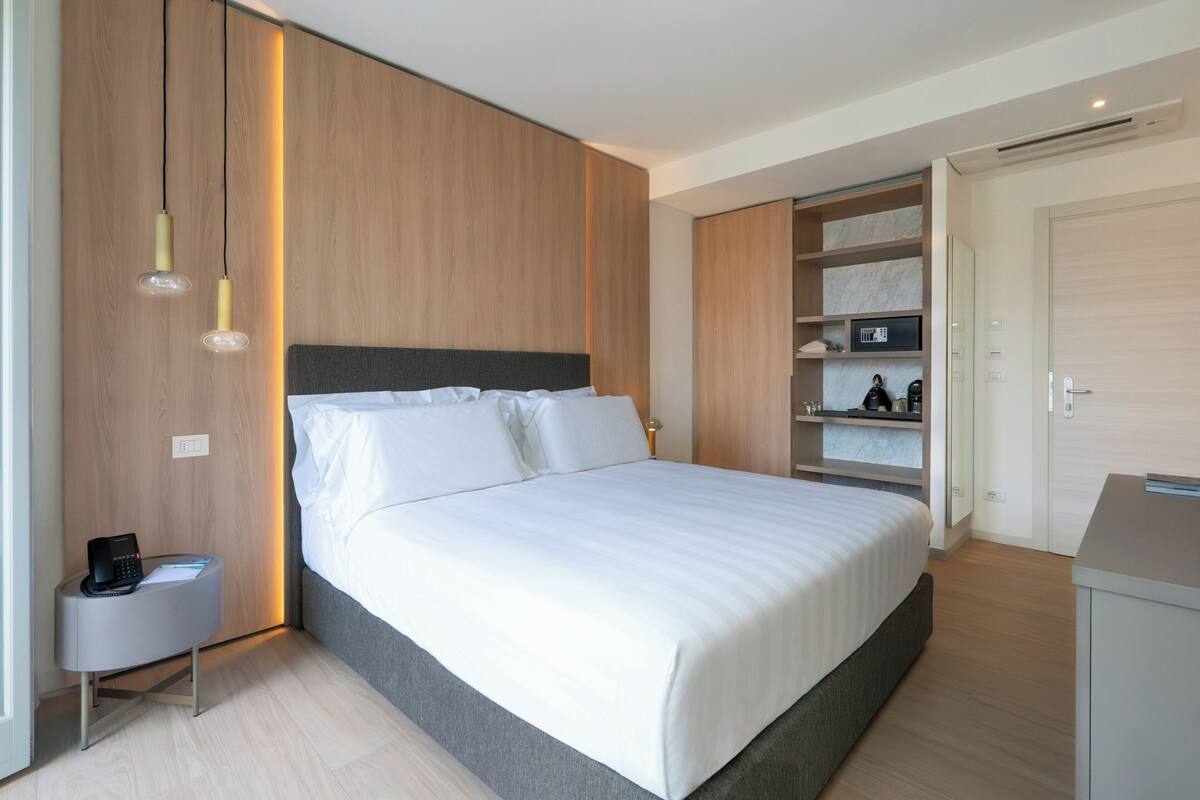 Une chambre moderne avec un grand lit, des tables de chevet et des étagères intégrées.
