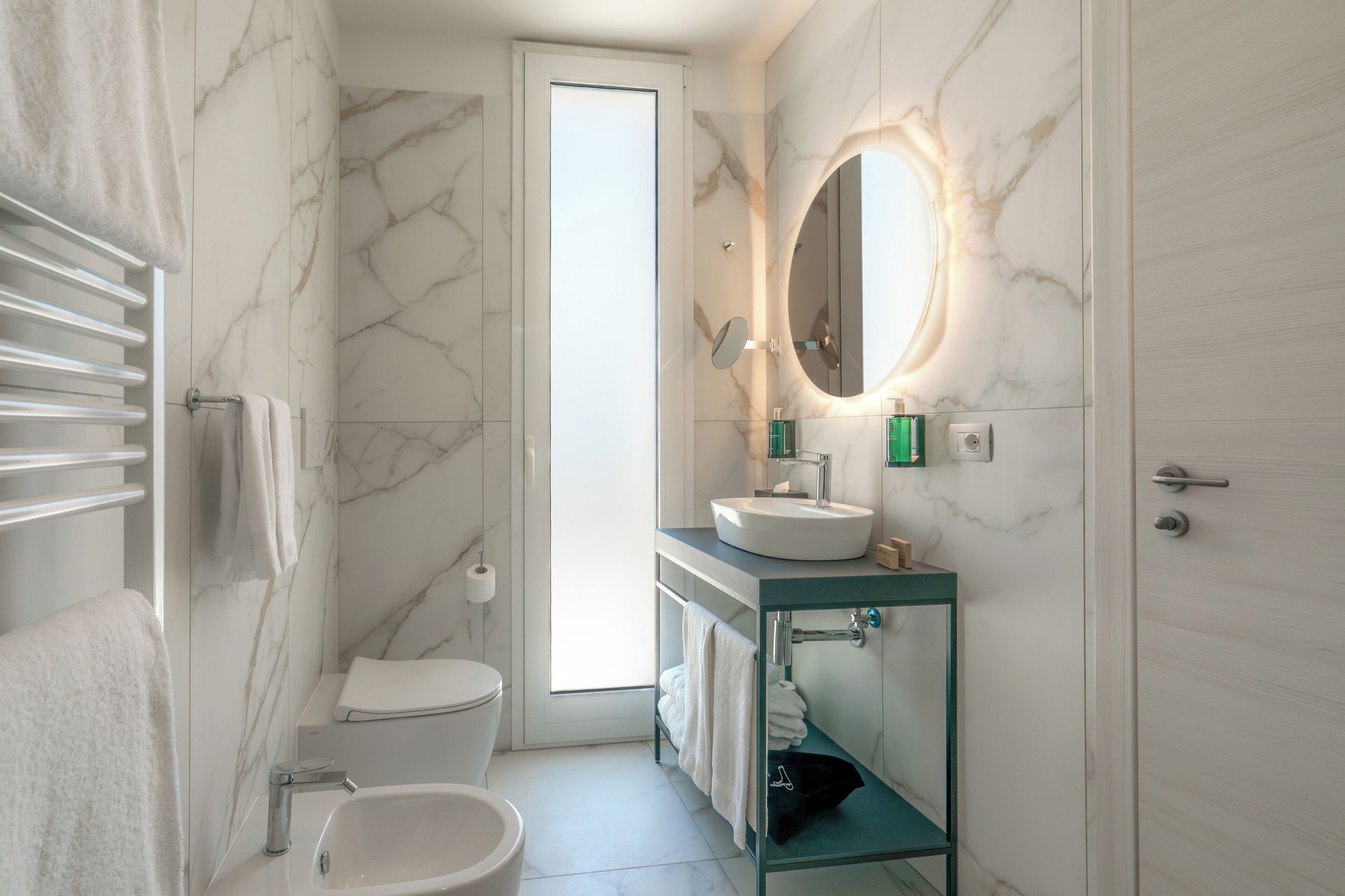 A modern bathroom with a toilet, sink, and glass-enclosed shower.