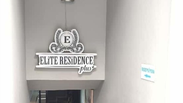 A hallway with a sign reading "ELITE RESIDENCE plus" and a reception area visible in the distance. - Elite Residence PLUS (Izmir)