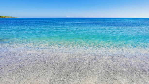 A clear view of a beach with shallow, turquoise water and a sandy shore. - Nicolaus Club Li Cucutti  (Agrustos)