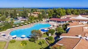 A resort with a large swimming pool, lounge areas, and a view of the sea. - Nicolaus Club Li Cucutti  (Agrustos)