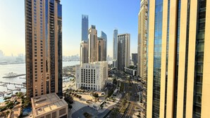 A high-rise urban area with modern buildings, a river, and a well-maintained public square. - Dancenter Luxury 2 BR at Creek Side (Dubai)