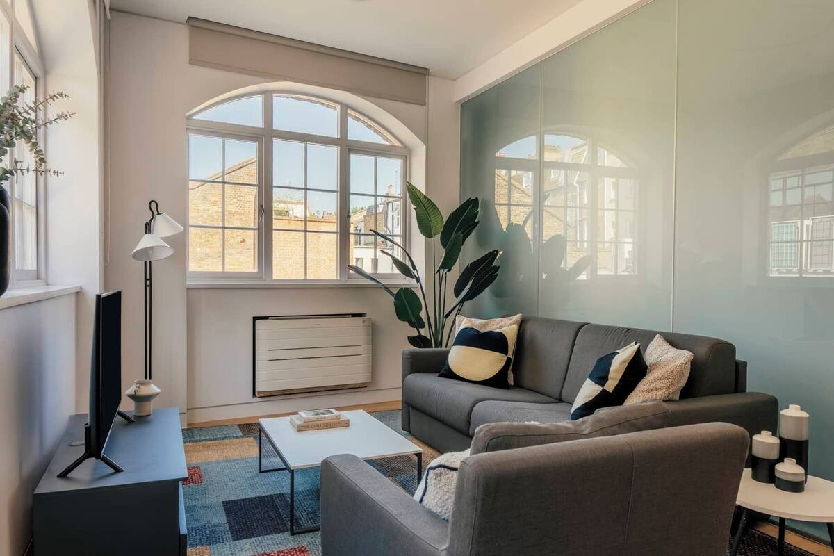 A modern living room with a sofa, coffee table, and a radiator.