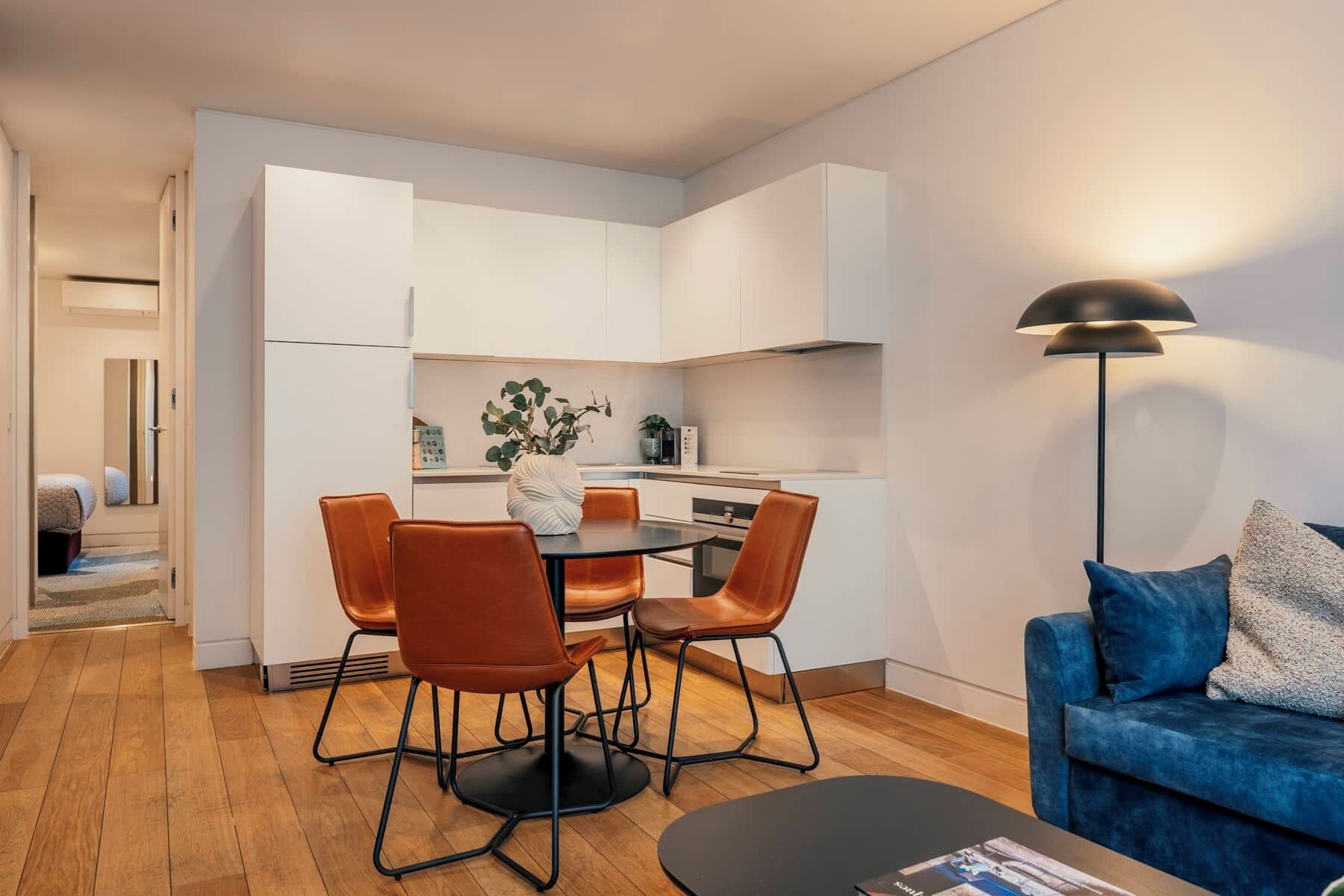 Un espace de vie compact comprenant un coin repas, une kitchenette et un canapé.