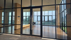 A modern building with large glass windows and a view of a cityscape. - Damansara Seresta (Batu Caves)
