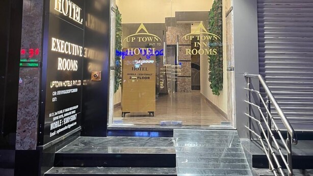 The entrance to Up Town Inn Hotel with a sign for Executive Rooms and a staircase leading up. - Uptown Inn (Bengaluru)