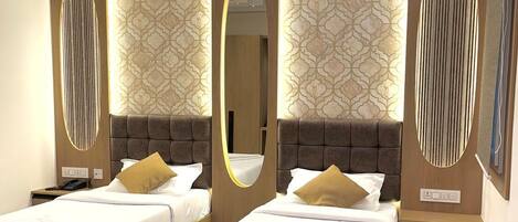 A modern hotel room with two beds, a large mirror, and patterned wallpaper.