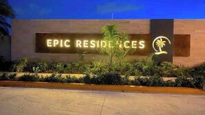 Ein Gebäude mit einem Schild, auf dem „EPIC RESIDENCES“ steht, und einem Palmenlogo.