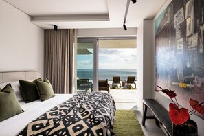 A bedroom with a large bed, a view of the ocean, and a painting on the wall. - An African Story by RETURN Africa (Cape Town)
