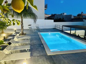 A rooftop pool area with lounge chairs and a palm tree. - Suite Costa Sicana (Siculiana)