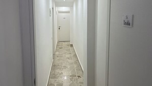 A narrow hallway with a stone floor leading to a door marked "Double." - Suite Costa Sicana (Siculiana)