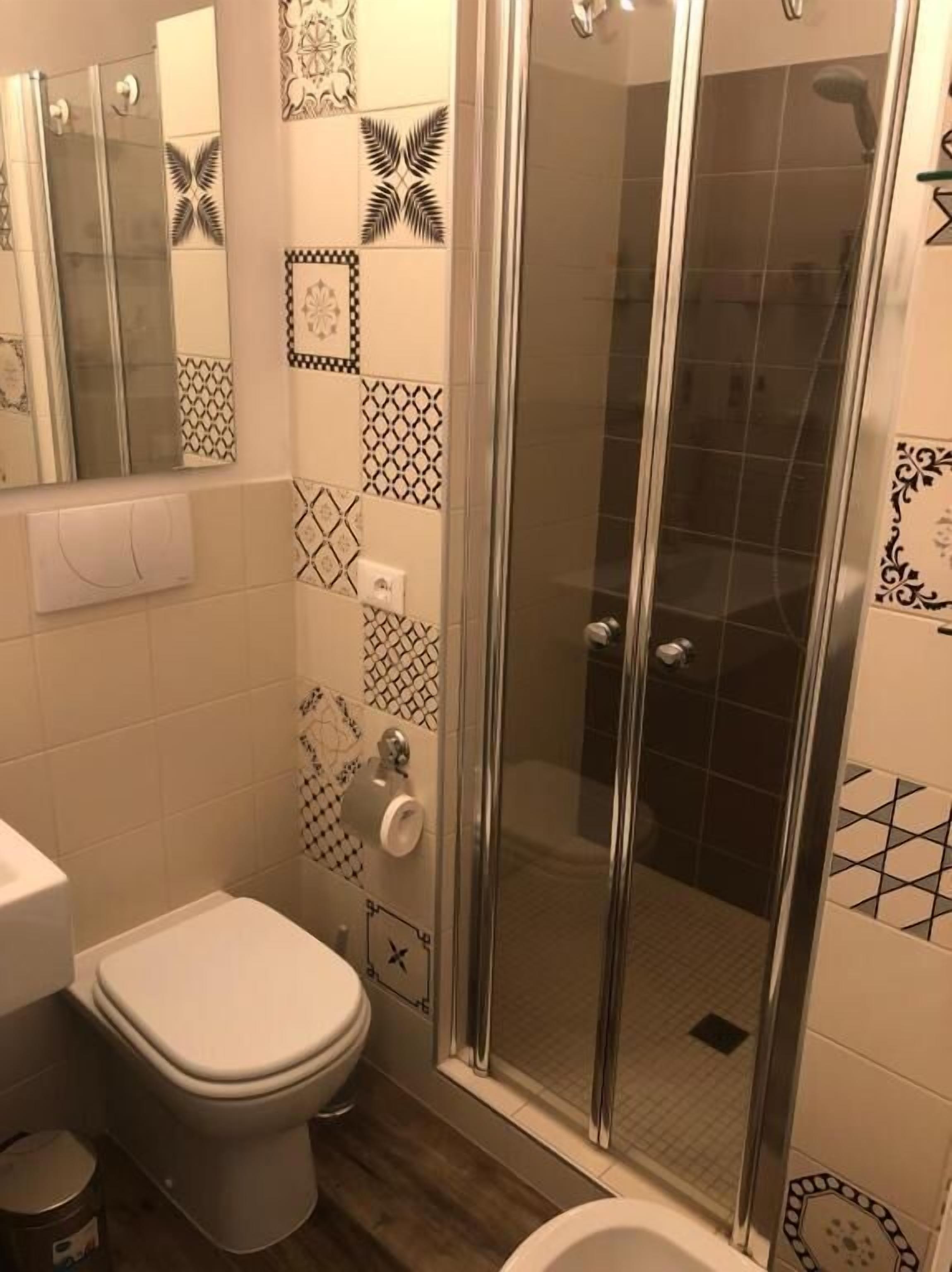 A bathroom with a toilet, a bidet, and a shower with a glass door.