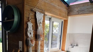 Eine kleine Küche mit Holzschränken, einem integrierten Spülbecken und einem Fenster, das für natürliches Licht sorgt.