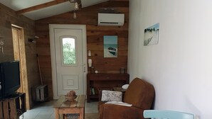 Ein gemütliches Wohnzimmer mit Holzboden, einer Couch, einem Couchtisch und einem Fernseher.