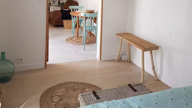Ein Zimmer mit einer hölzernen Bank, einem Tisch und einer Pendelleuchte.