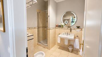 Une salle de bain moderne avec une douche à parois de verre, un lavabo avec un miroir et des toilettes.