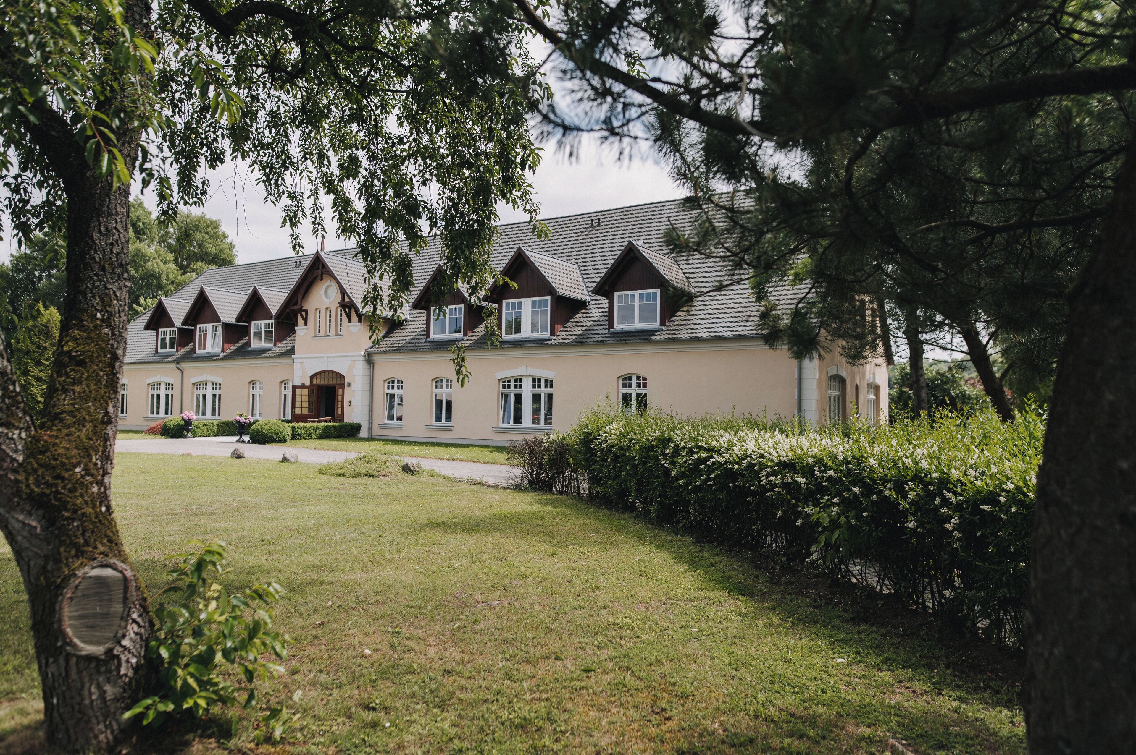 Un grand immeuble à plusieurs étages, doté d’une façade symétrique, de nombreuses fenêtres et d’une entrée centrale.