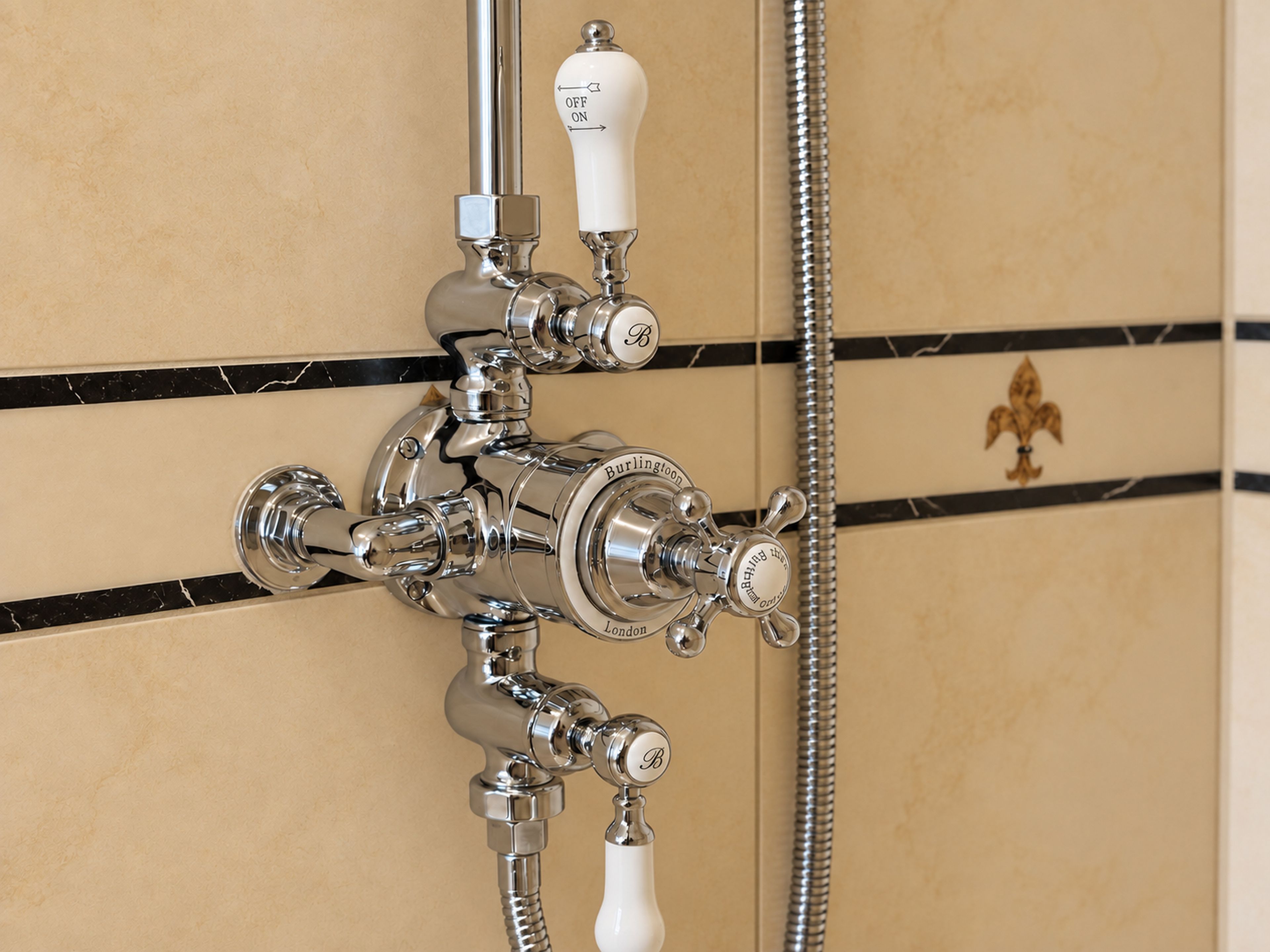 Un baño con ducha de acero cromado y grifo empotrado.
