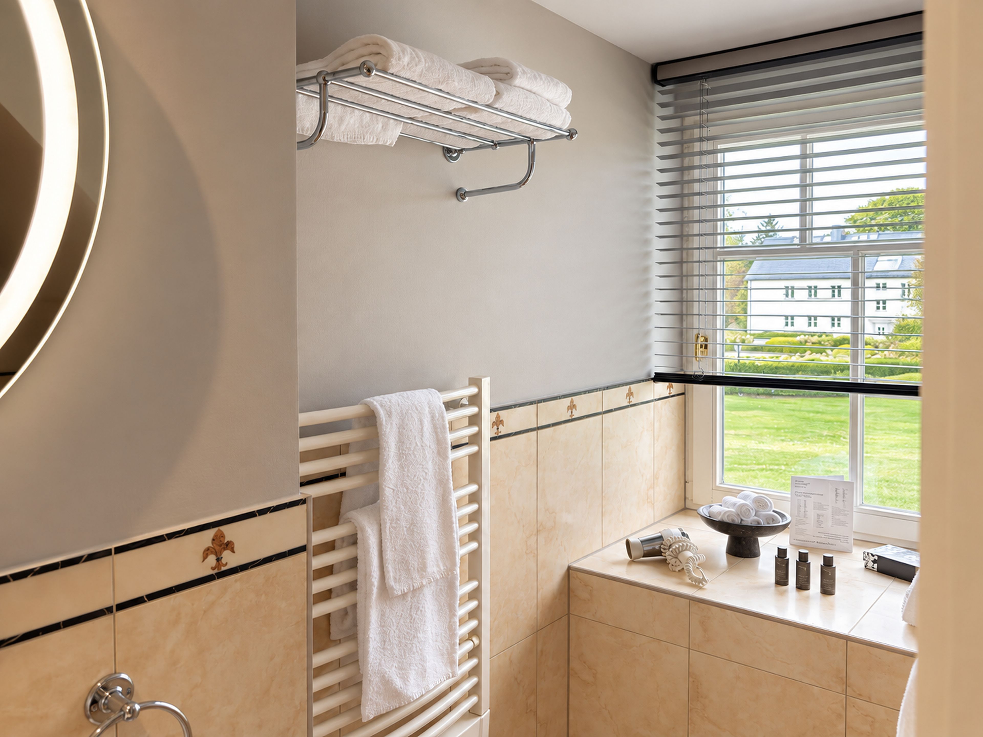 A bathroom with a towel rack, a window with blinds, a sink with toiletries, and a mirror.