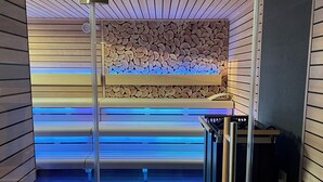 Ein moderner Wellnessraum mit einer Holzwand und einem blauen Massagebett.