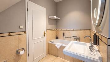 A modern bathroom with a bathtub, a sink, and a toilet.
