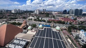 A cityscape with high-rise buildings, a solar panel array, and a mosque with a distinctive dome. - Pyramid Spacious Lovely Couple Suites双威城公寓式套房 (Petaling Jaya)