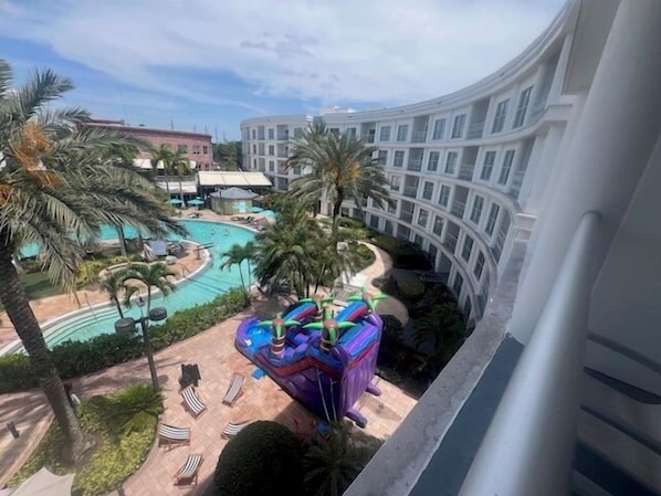 Een hotel met een zwembad, inclusief een glijbaan en ligbedden.