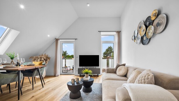Una sala de estar moderna con comedor, un televisor de pantalla plana y un gran ventanal con vistas al exterior.