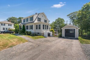 A two-story house with a garage, a driveway, and a lawn. - Pet-Friendly York Beach Vacation Rental | Walk to Cape Neddick Beach (York)