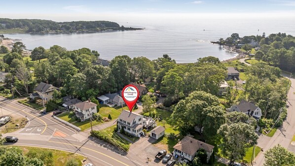 An aerial view of a residential area with houses, roads, and a large body of water in the background. - Pet-Friendly York Beach Vacation Rental | Walk to Cape Neddick Beach (York)