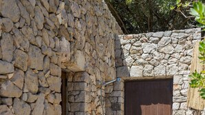 A stone-walled building with a wooden door and a small window. - Villetta Sulvia - Alloggio Alaterno con Terrazza Vista Mare (Corsano)