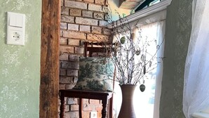Un escalier avec un mur en briques, une table en bois avec un vase et une chaise.