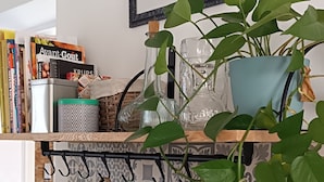 Una cocina con tetera, cafetera y un colgador para ollas.
