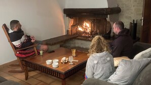 A cozy living room with a fireplace, a wooden coffee table, and two sofas.
