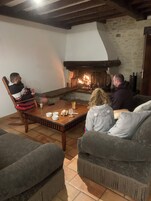 Uma sala de estar acolhedora com lareira, uma mesa de centro de madeira e dois sofás.